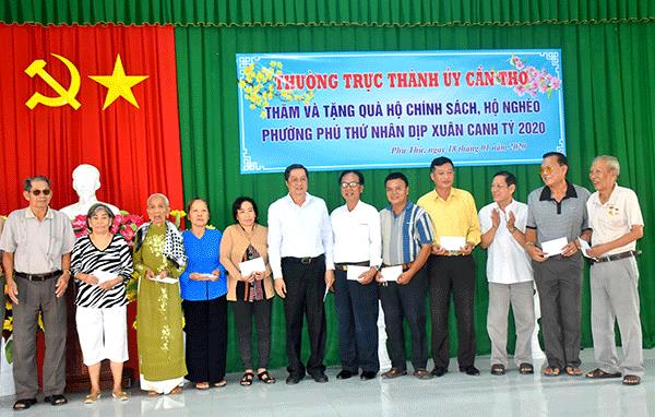 Đồng chí Phạm Văn Hiểu, Phó Bí thư Thường trực Thành ủy, Chủ tịch HĐND TP Cần Thơ (thứ 6, từ trái sang), tặng quà các gia đình chính sách ở phường Phú Thứ, quận Cái Răng. Ảnh: X.Đào.